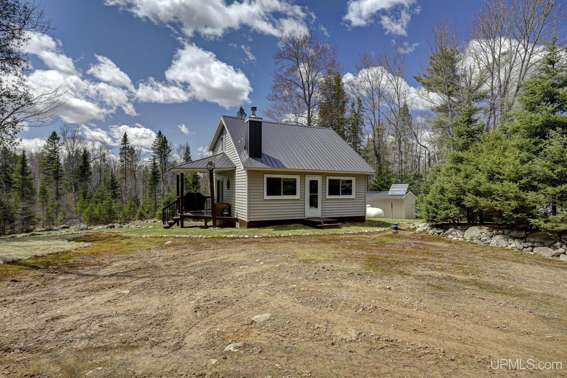 The cabin from the clearing in front, a covered porch on the near end