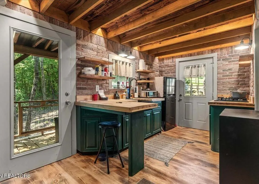 The open living room with a wood stove and vaulted ceiling