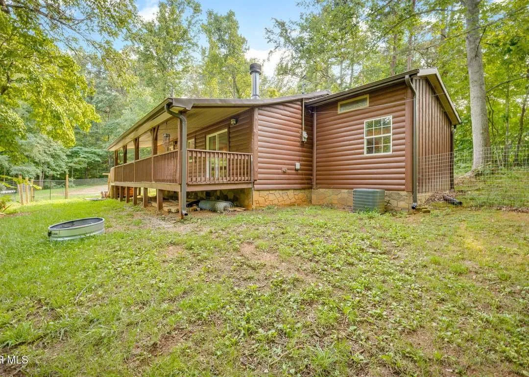 The home from a second angle, open field visible beyond the porch