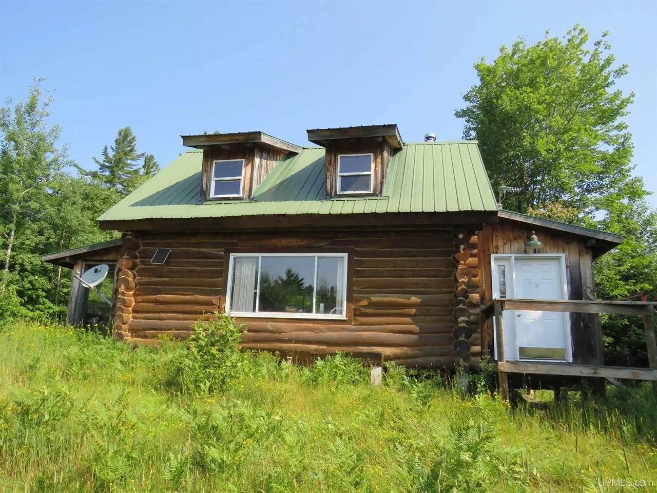 The front of the cabin, two dormer windows above the porch