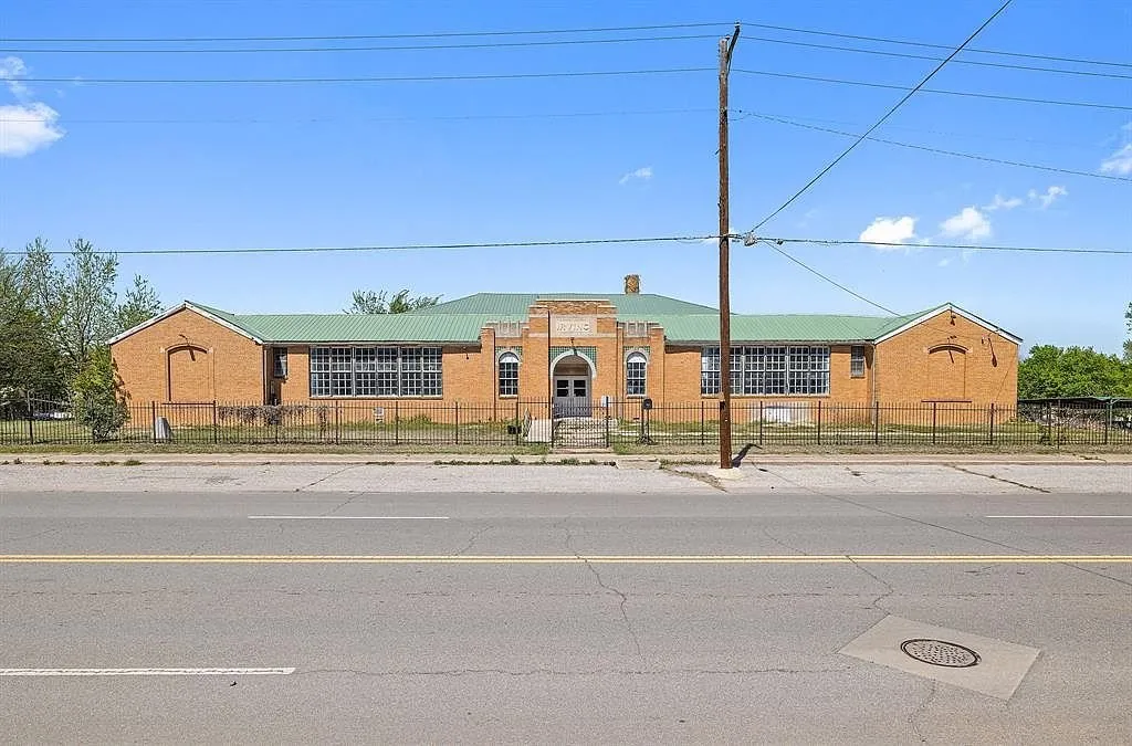 The school from across Foreman Street with its long wings and green metal roof