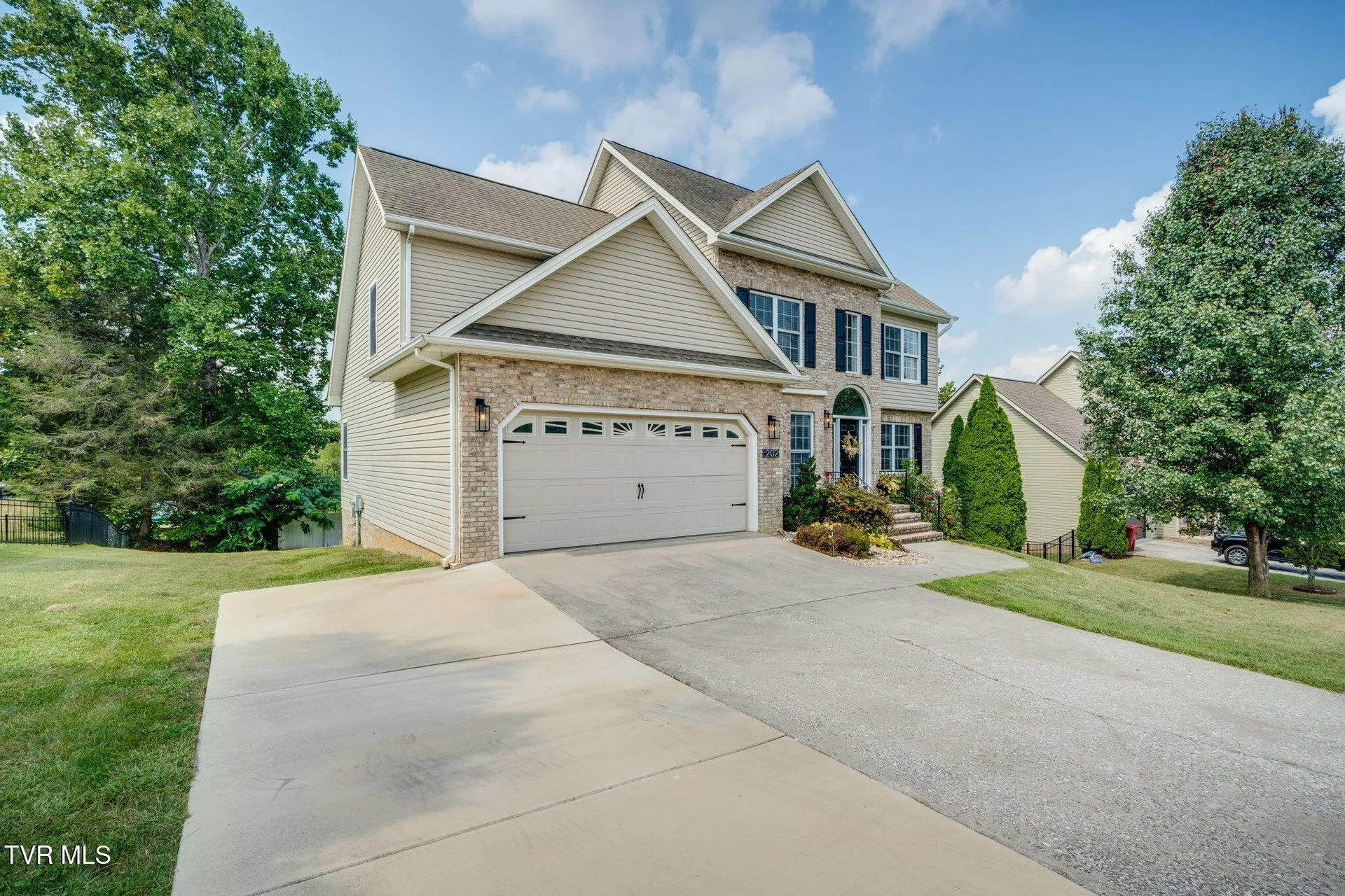 The house from the street with the extended driveway running to the garage