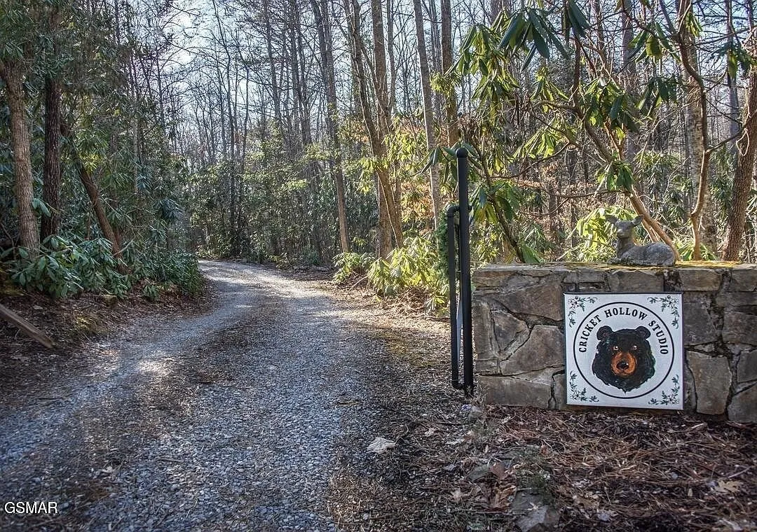 The gravel drive coming in past a carved property sign set in stone
