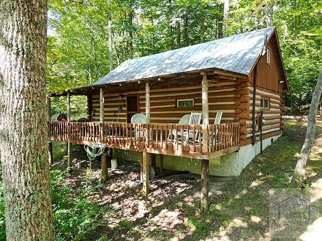 The cabin from the side with the deck rail and chairs