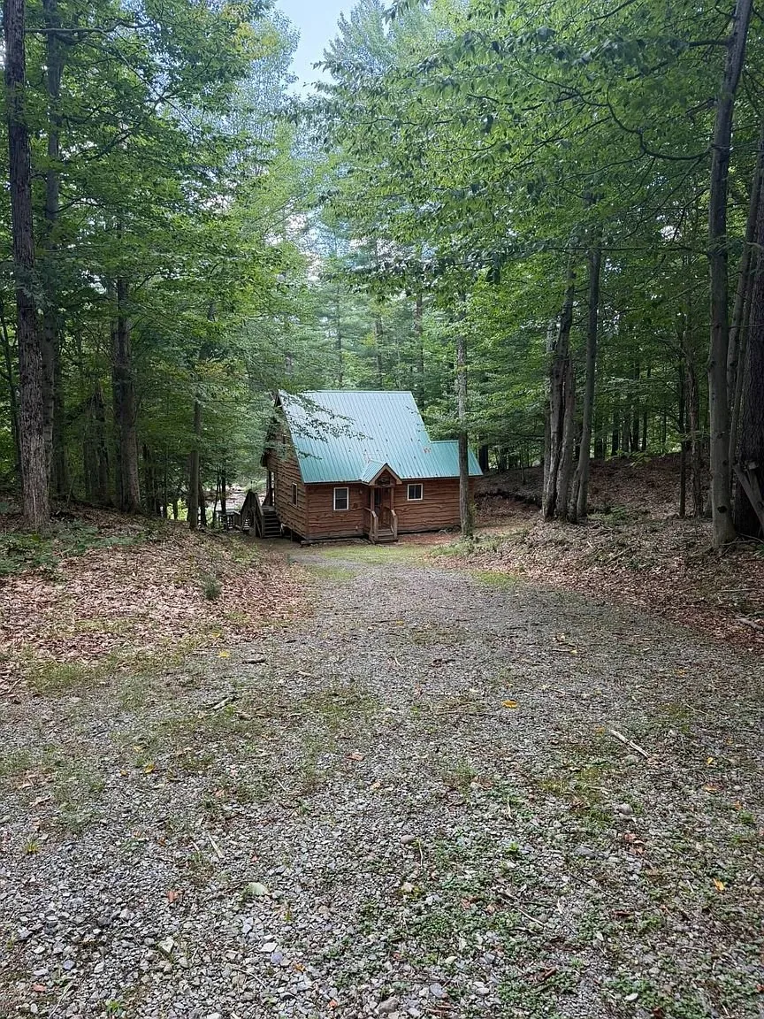The chalet with its green metal roof at the end of the gravel drive