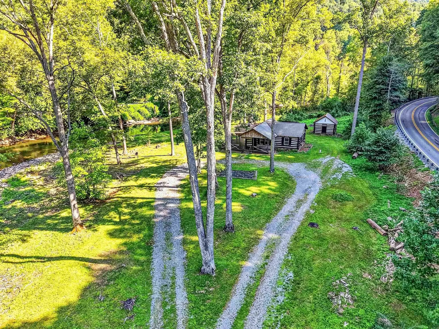 Aerial of the drive winding in through the trees toward the cabin