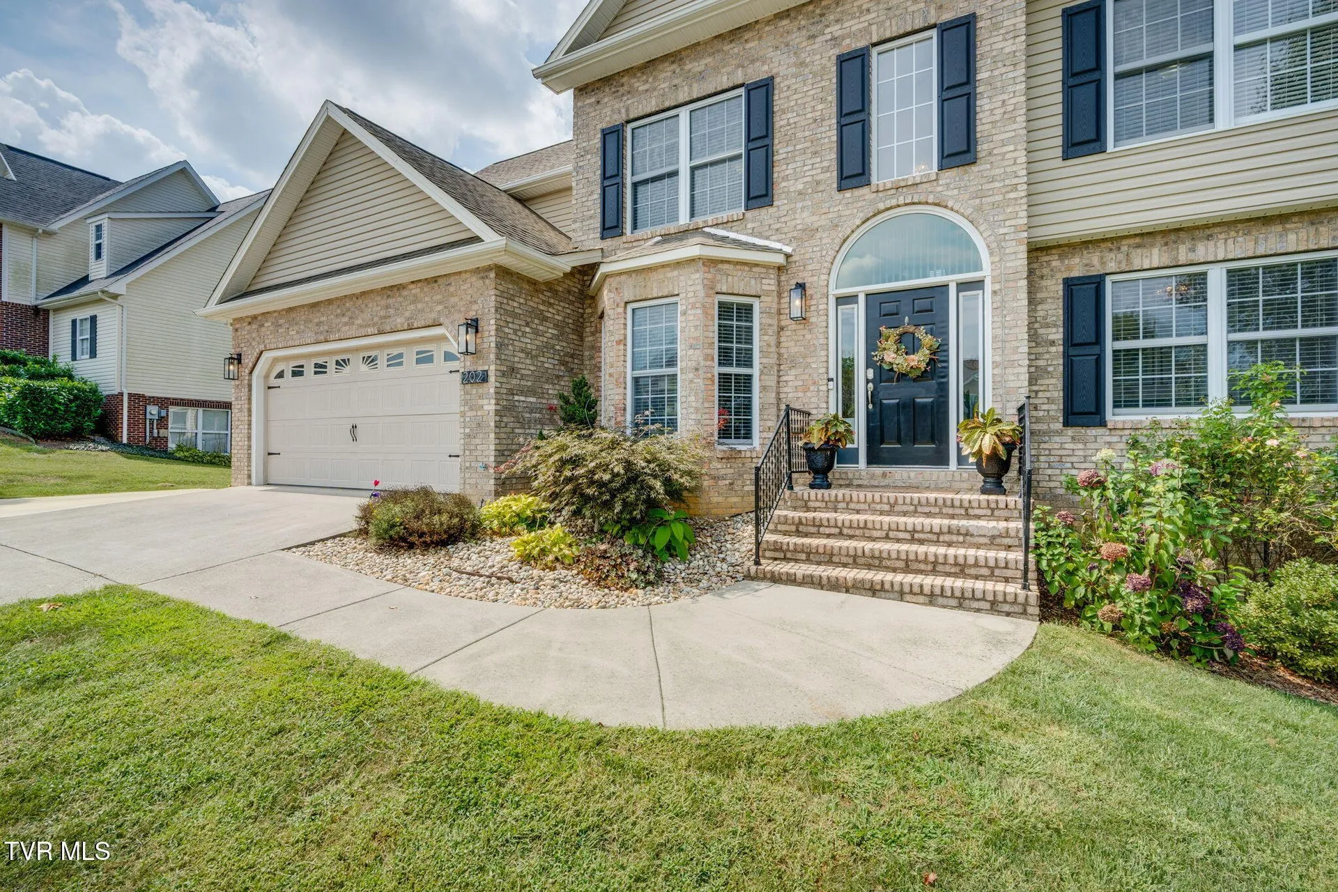 The front walk and steps up to the covered entry with landscaped beds