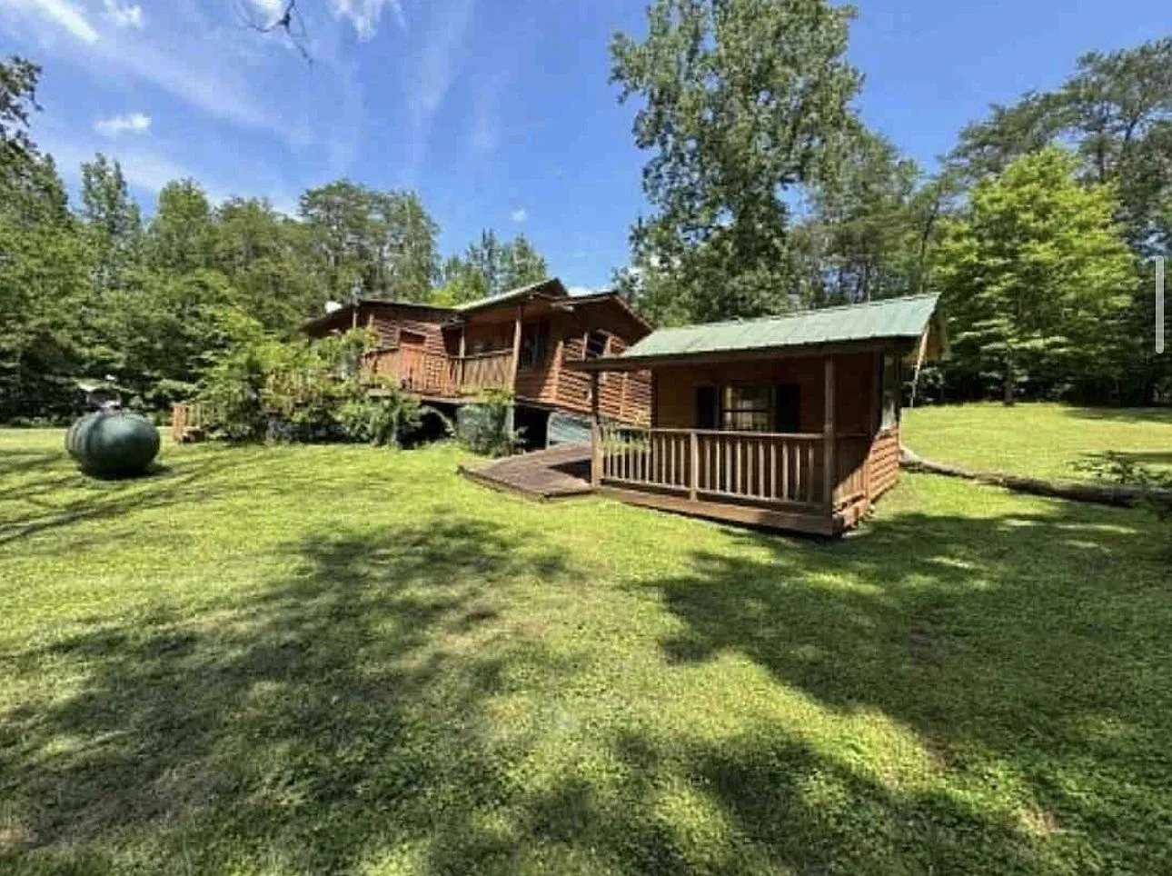 The cabin's covered porch and metal roofline from the yard