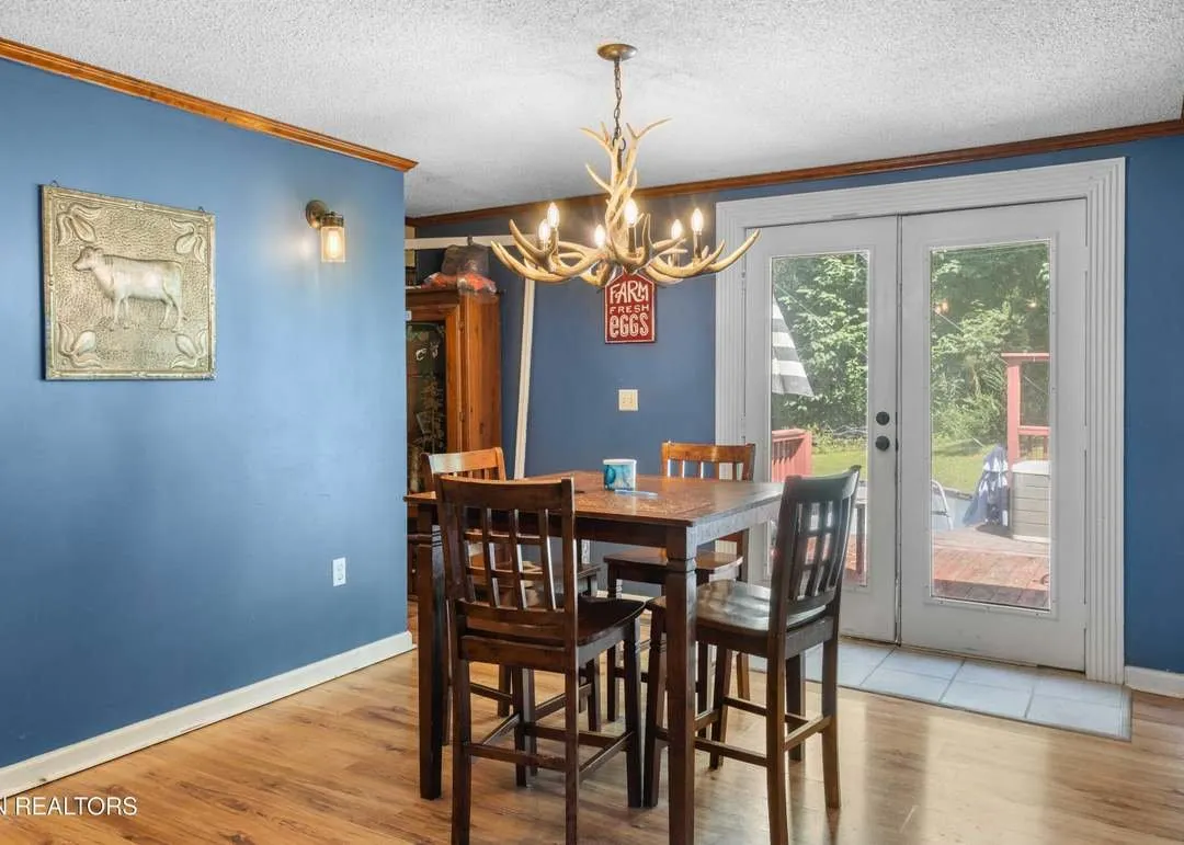 The dining area with a wood table set near glass doors