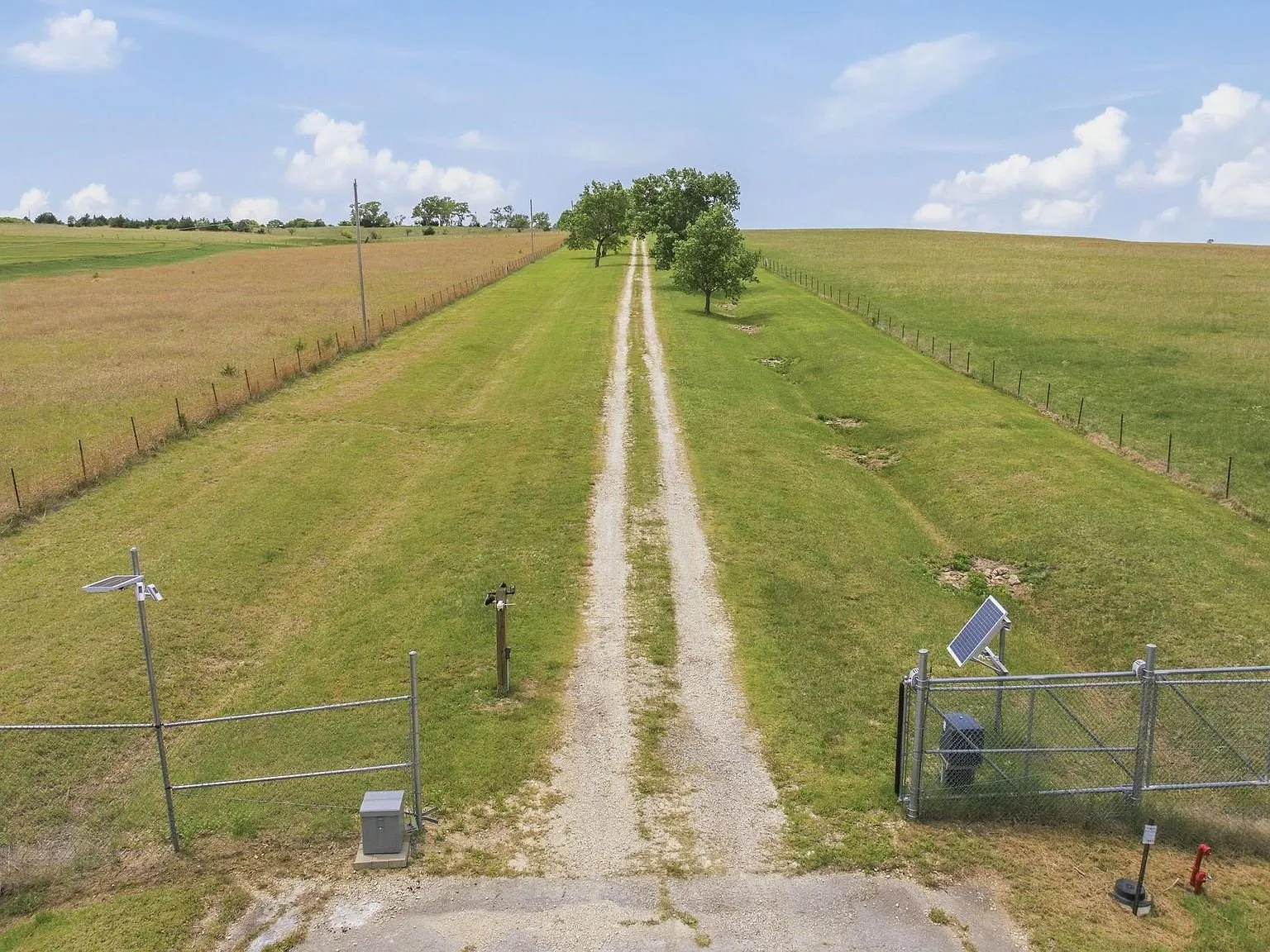 The long gravel driveway leading in from the gate at the road