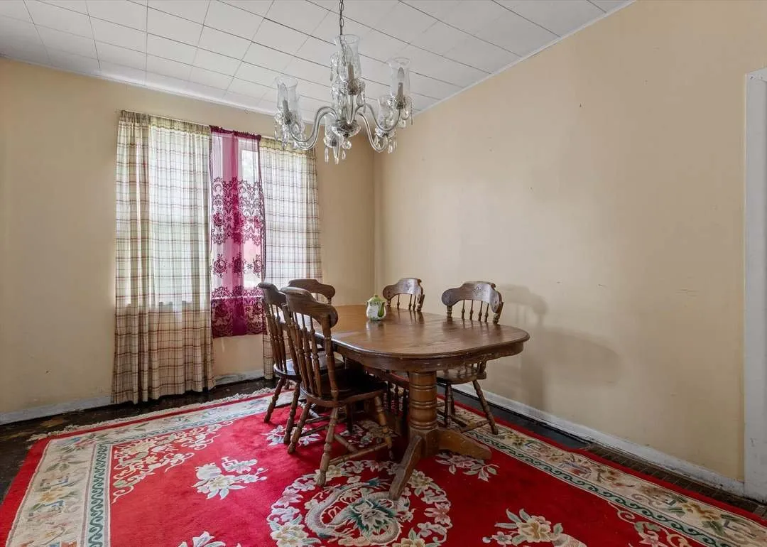 The dining room with a wood table and patterned rug