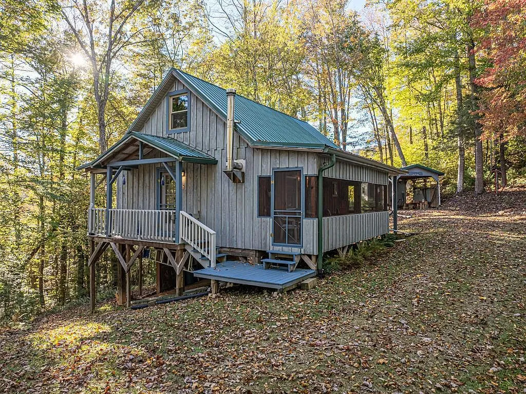 The cabin's gabled front with covered porch and screened porch addition
