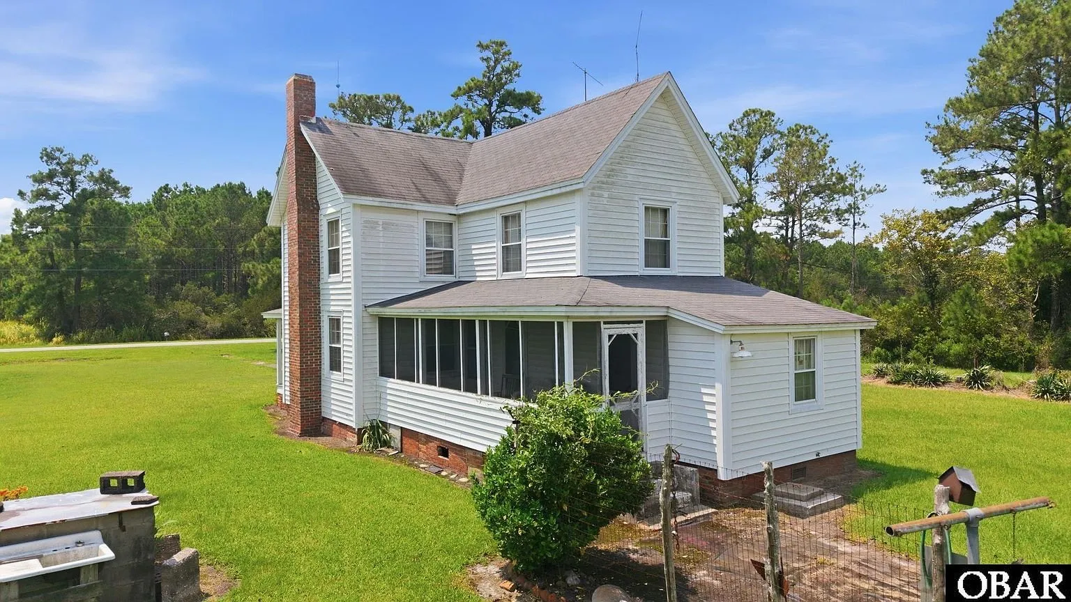 The rear of the house with the screened porch and the kitchen wing