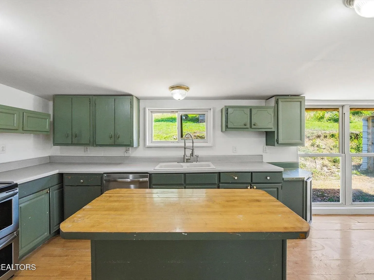 The updated kitchen with gray cabinets and a center island