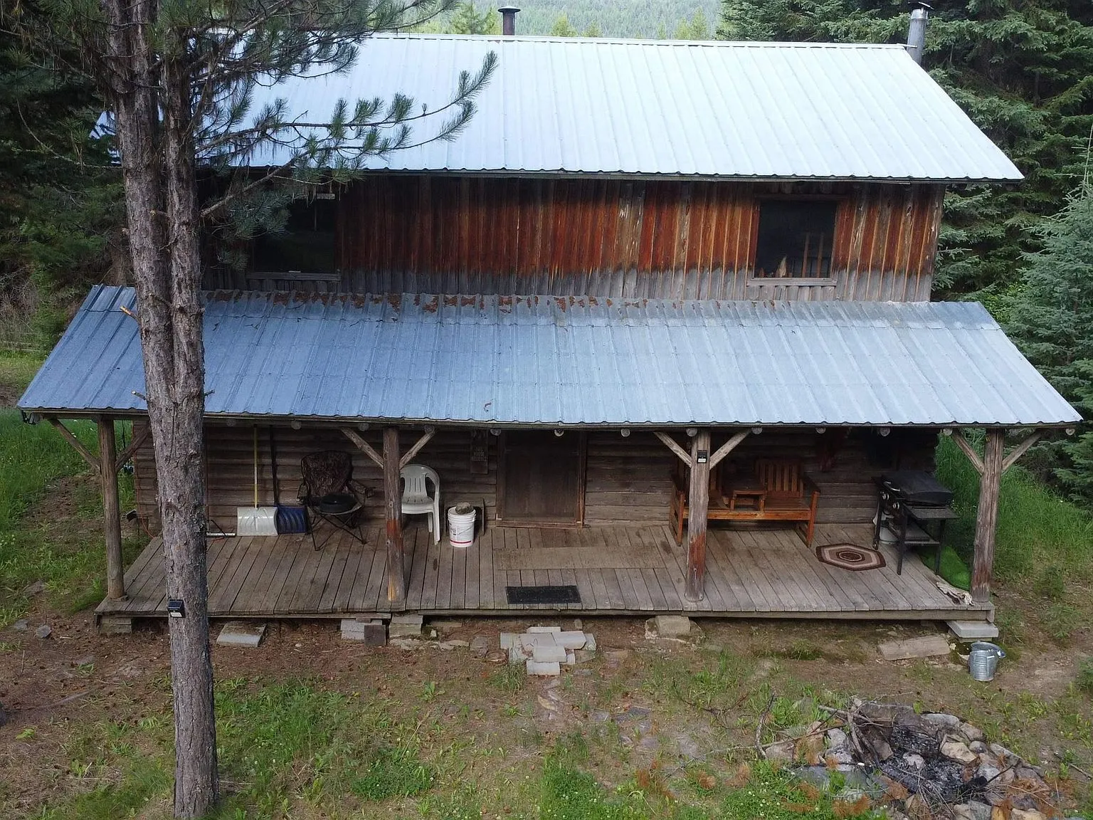 The log cabin tucked among tall pines, with its covered front porch