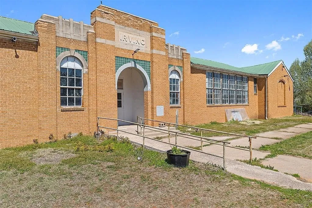 The entrance bay with the arched door, the steel windows and the cracked walk