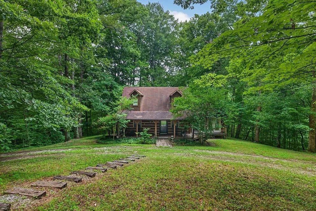 The wooded front yard and tree line in front of the home