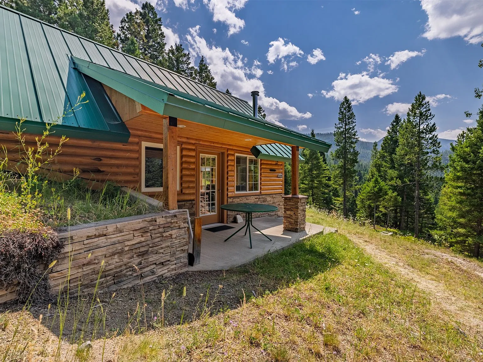 A side view of the cabin's covered entry and wraparound deck
