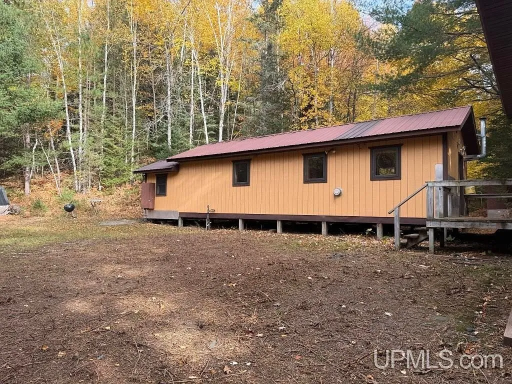 The cabin's exterior with its covered entry and propane tank