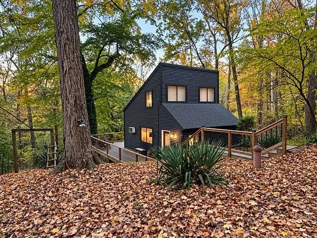 A second exterior view of the cabin's modern angled roof and deck in autumn color