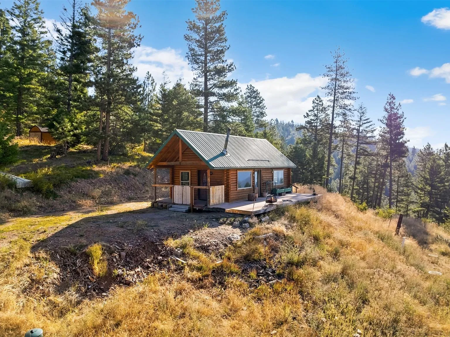 A closer aerial view of the cabin on its cleared hilltop site