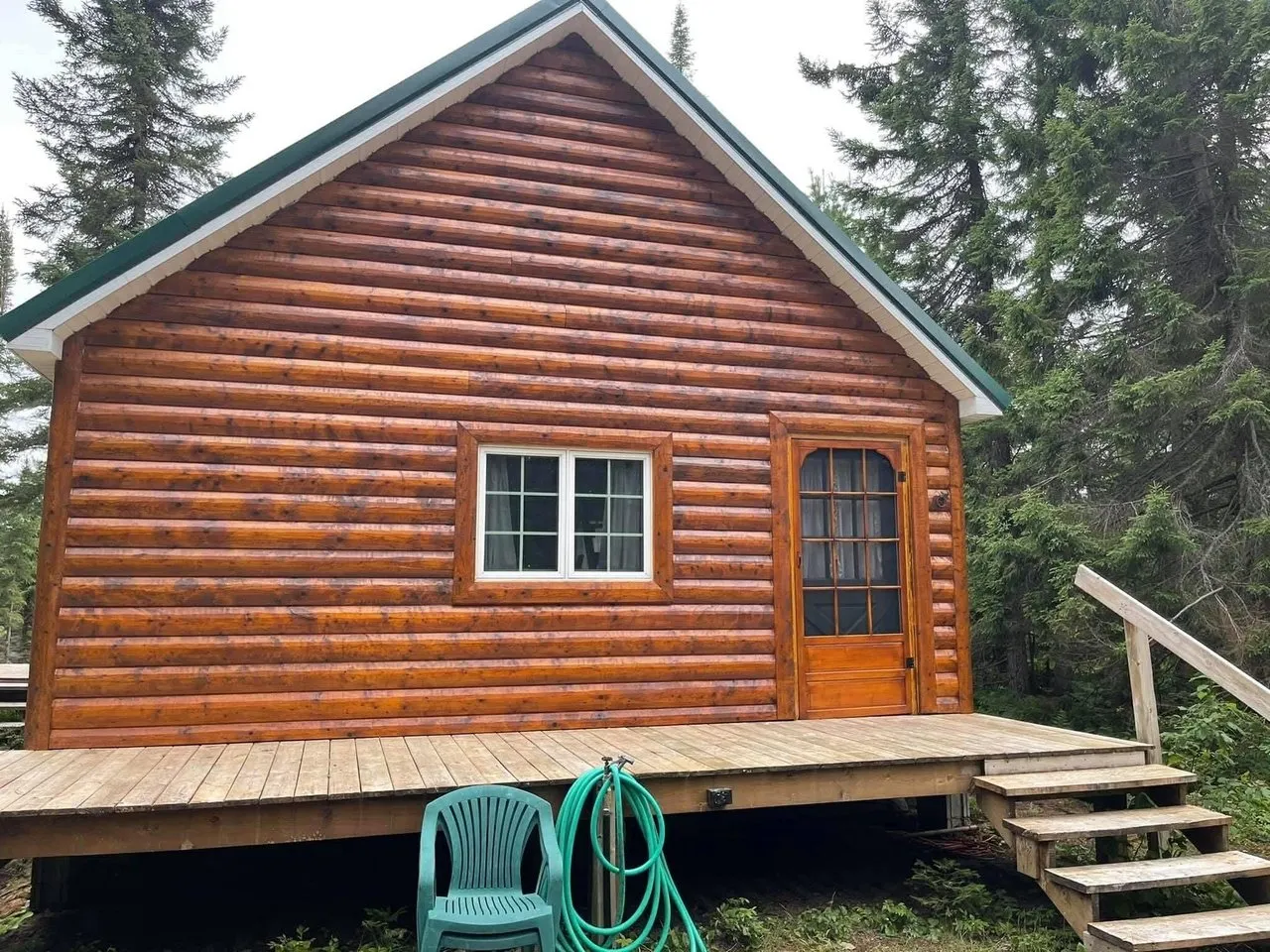 The front of the cabin with its deck and green chair