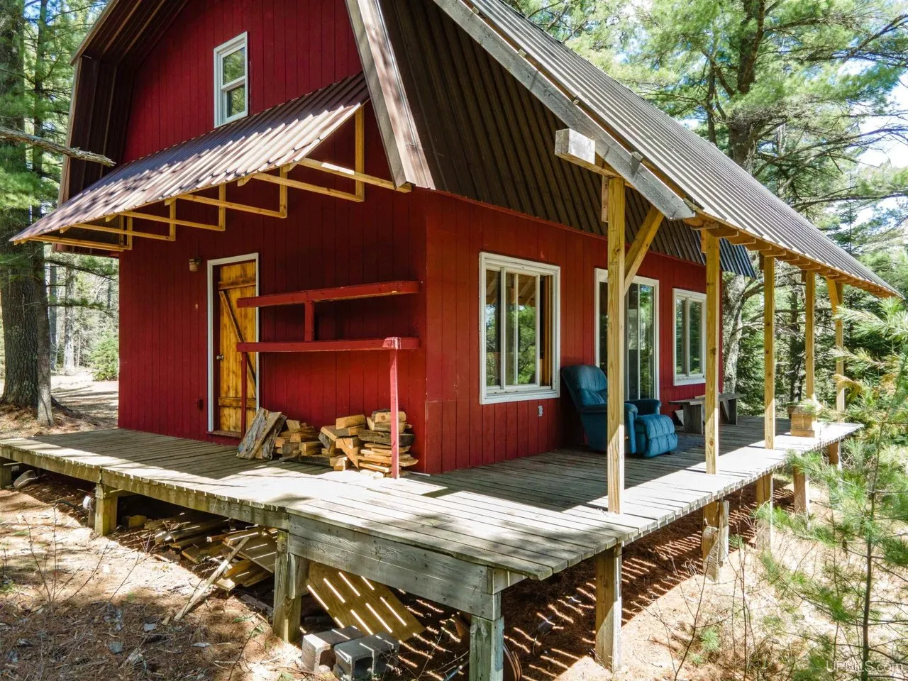 The side of the camp and the length of the deck under the pines