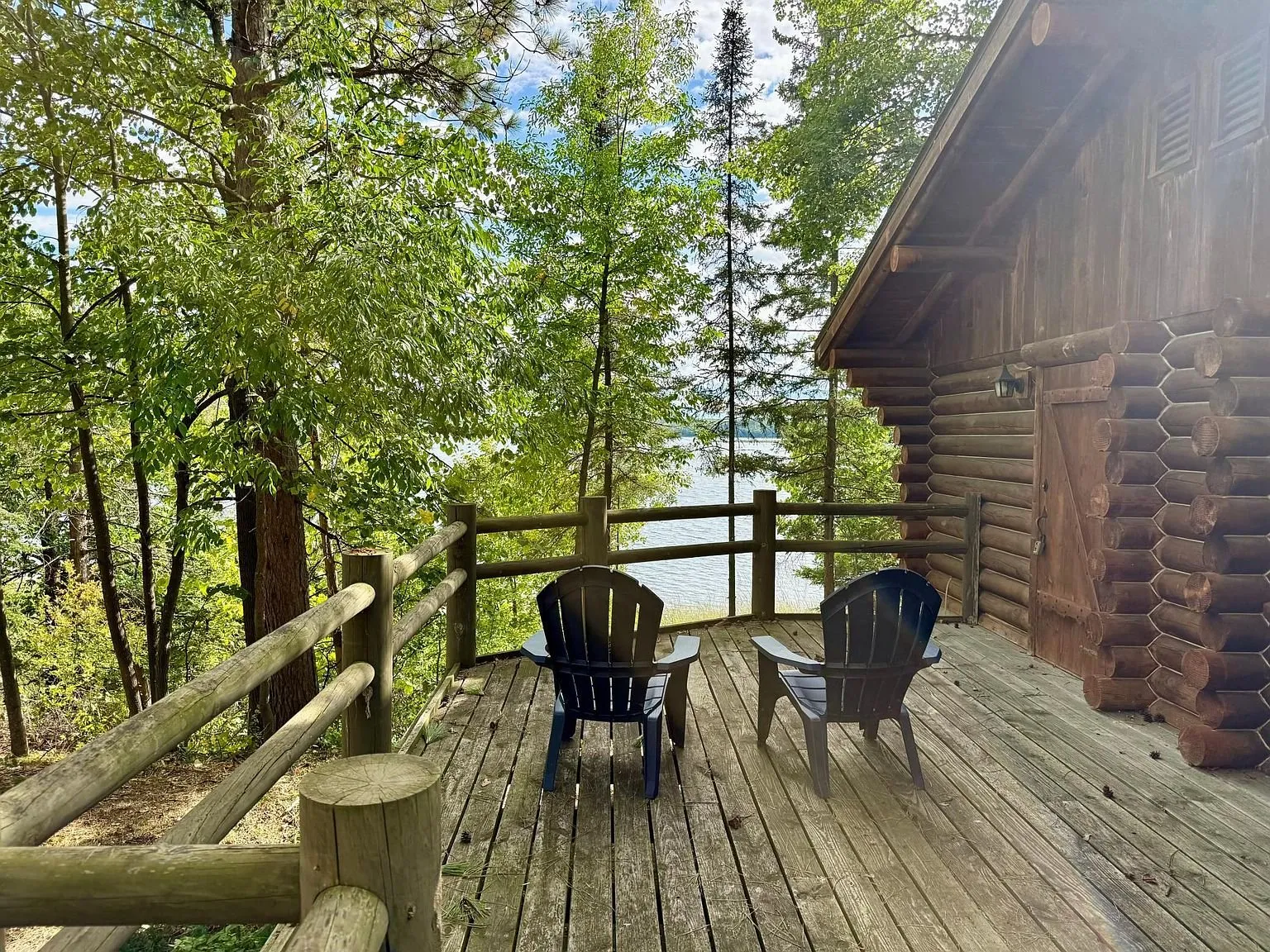 The deck with two chairs and the lake through the trees