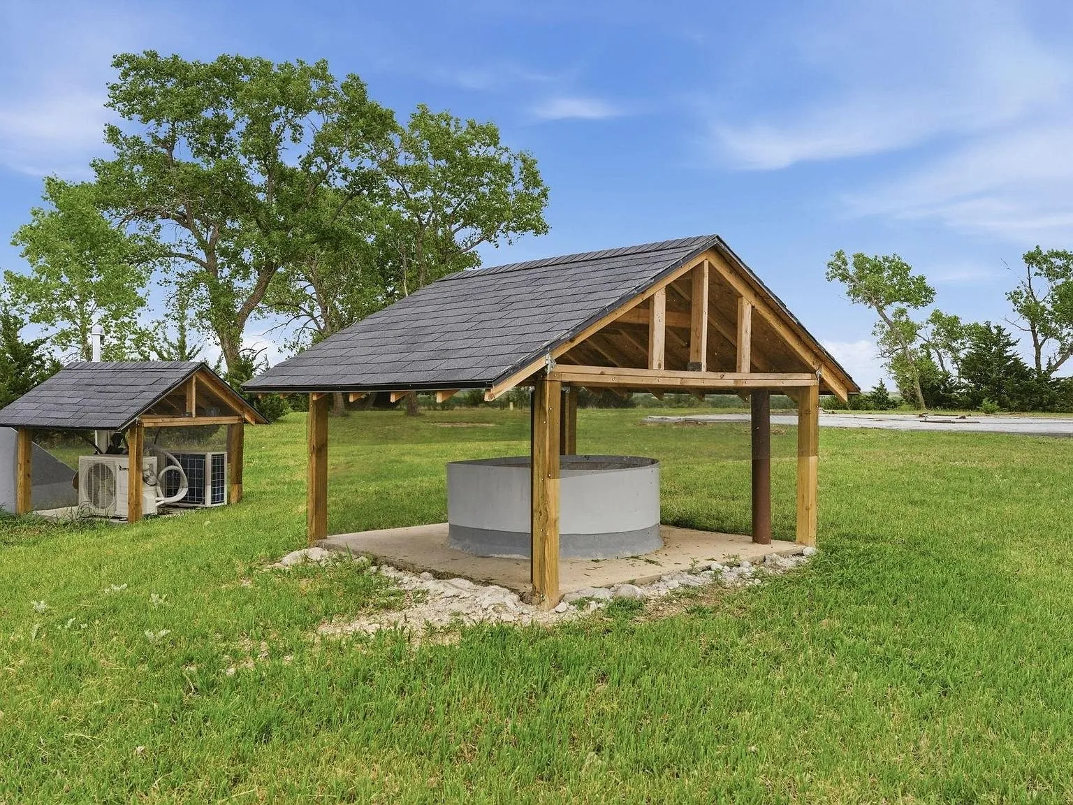 The carport structure with its peaked roof in the open field