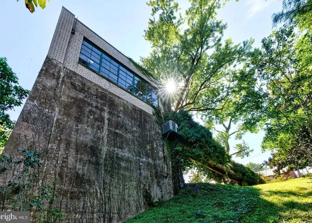 The concrete pump house tower rising above the tree line, backlit by the sun