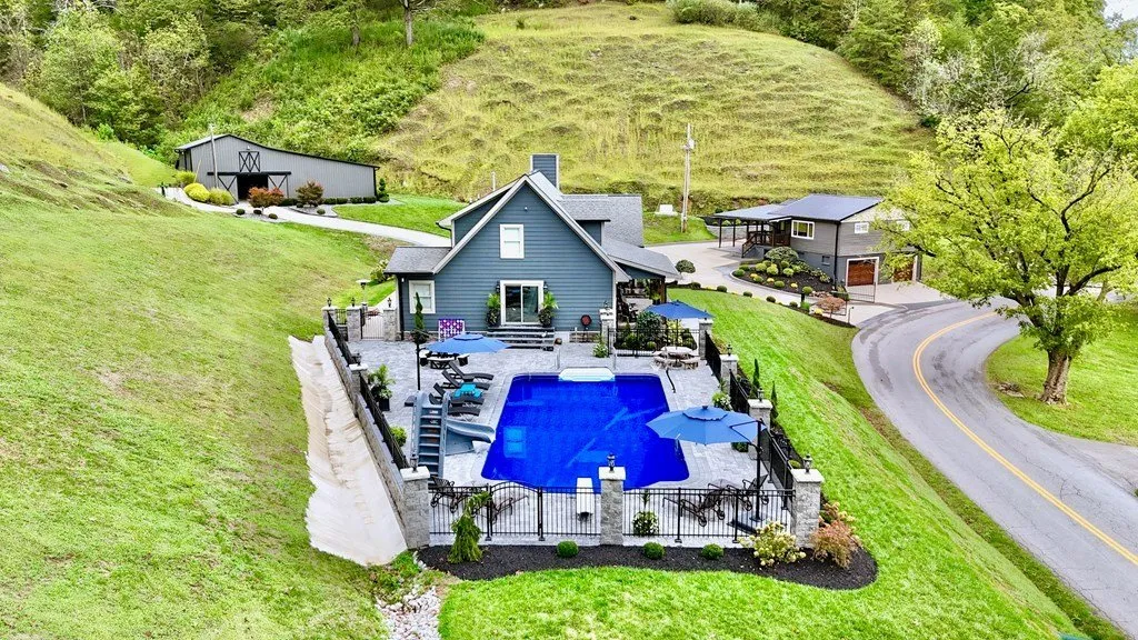 Aerial of the house, pool and drive with the pasture rising behind