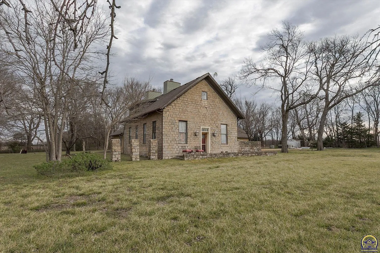 The schoolhouse and the addition from the lawn with the trees beyond