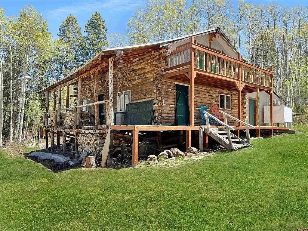 The side of the cabin with the deck stairs and the propane cylinders