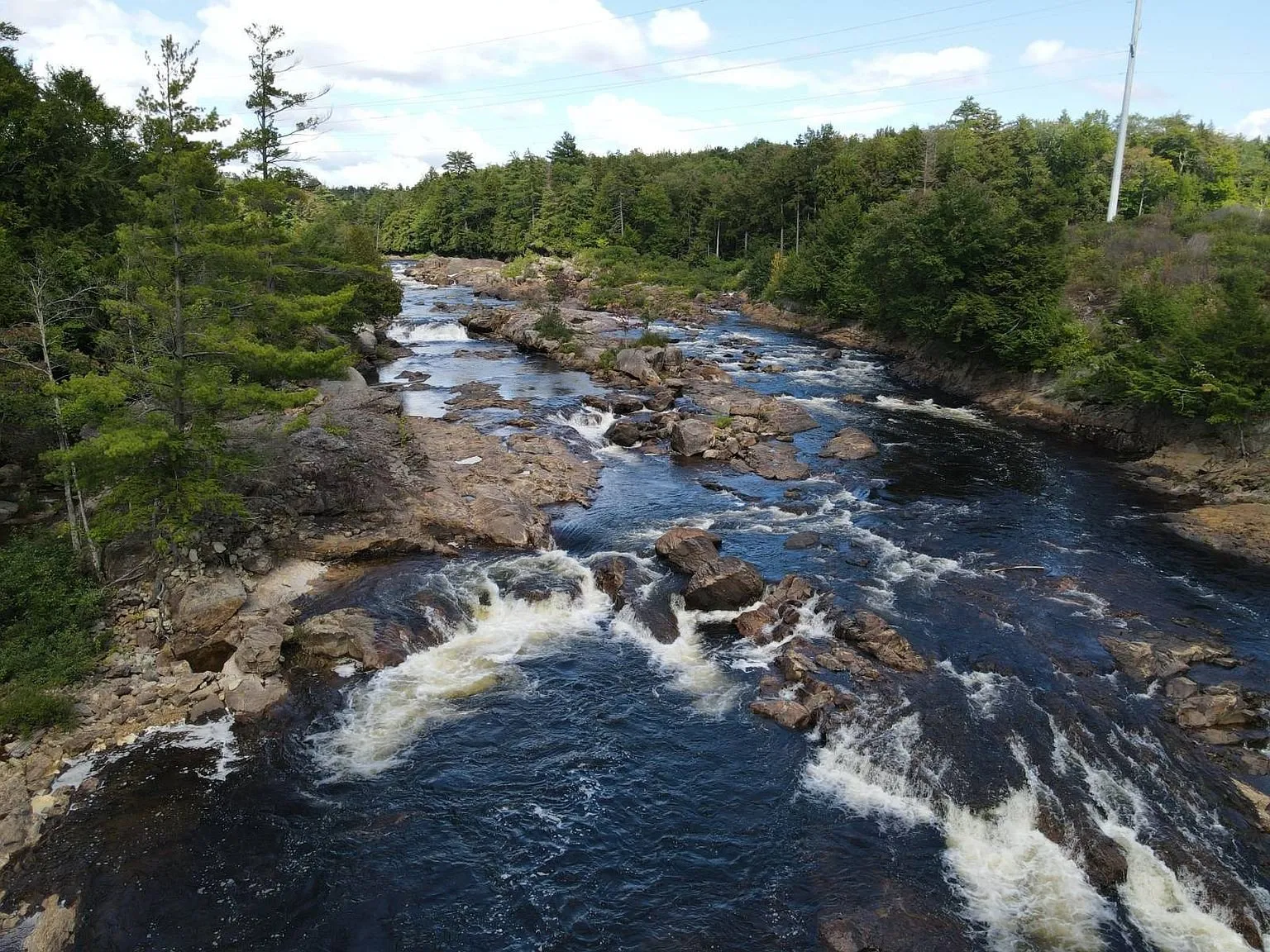 The Moose River pouring over the ledges with the pines on both banks