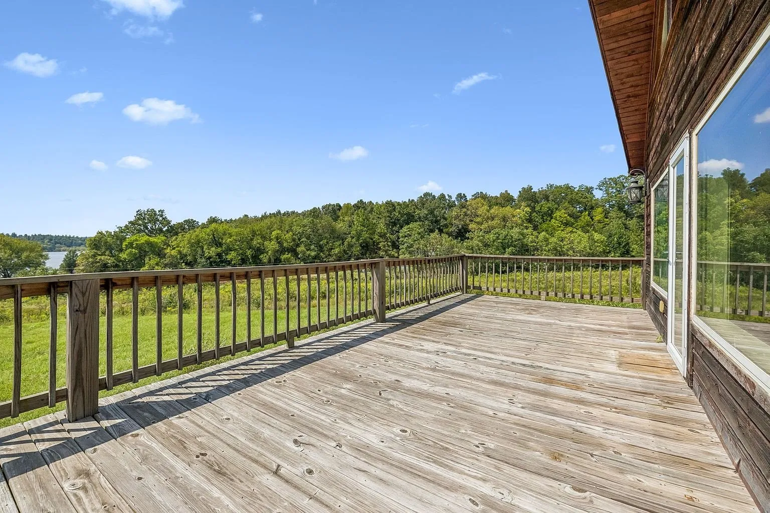 The deck rail looking over the field toward the trees