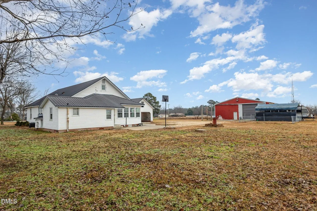 The house, the detached garage and the carport seen together across the yard
