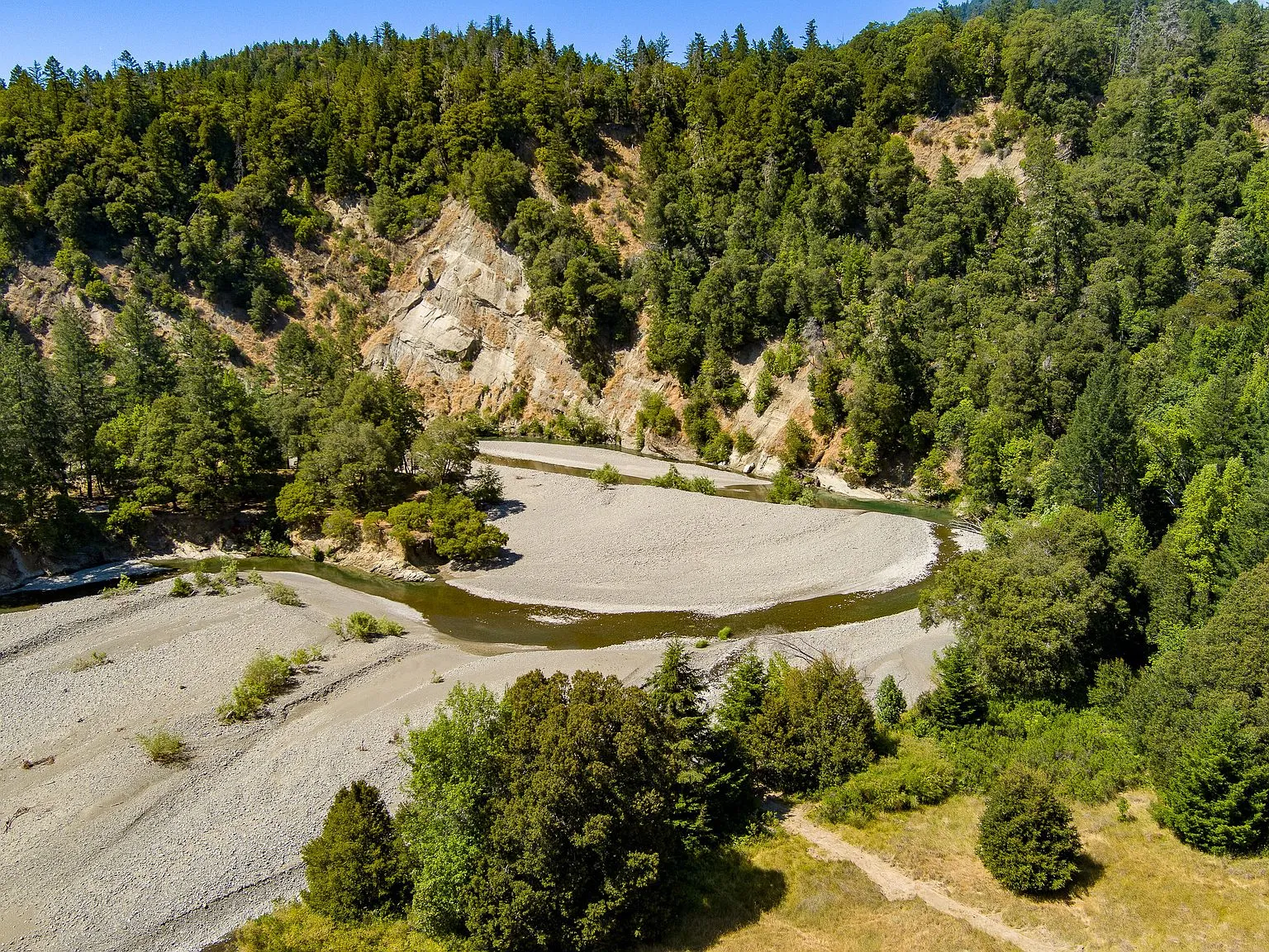 An aerial view of the permitted pond set into a cleared hillside meadow
