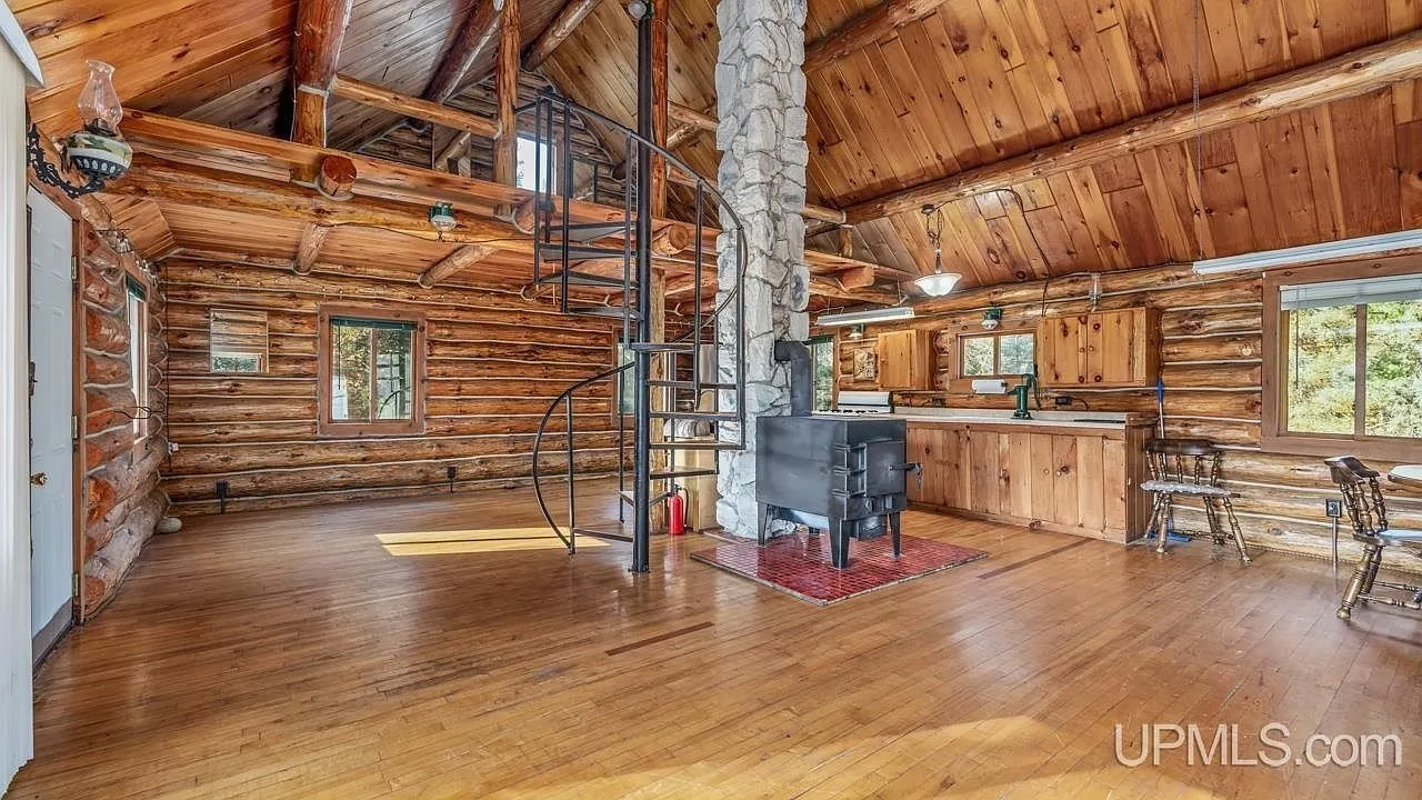 The great room's open floor plan with the wood stove and spiral staircase