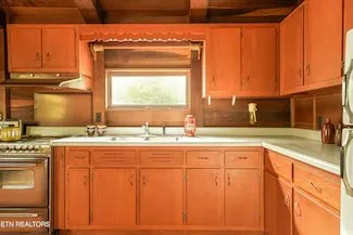 The kitchen sink and counter beneath a window