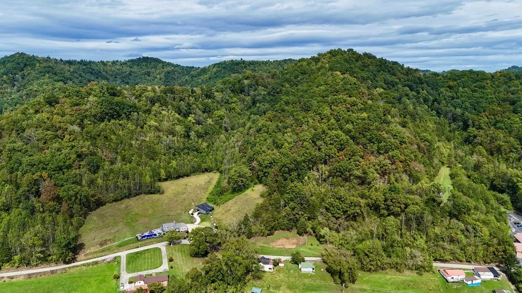 Aerial across the wooded ridges surrounding the property