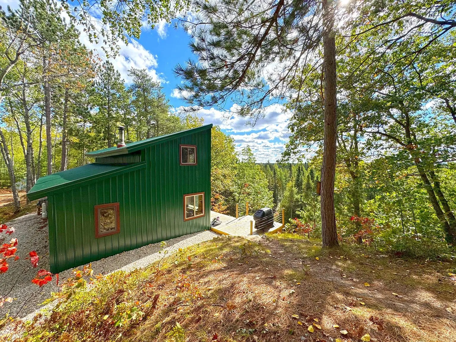 The green side of the cabin from the drive, autumn colour in the trees