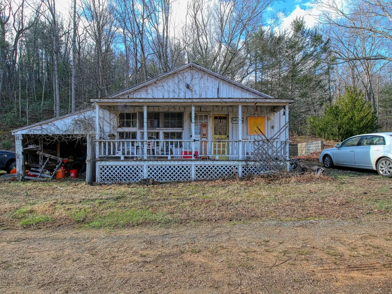 The country store at the front of the property, a low white building with a porch and two cars parked beside it