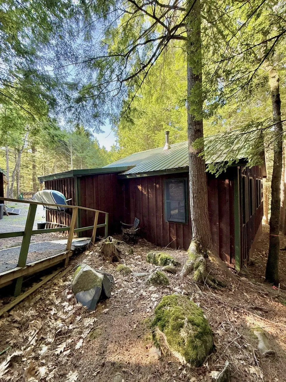 The back of the camp with the deck and the green metal roof