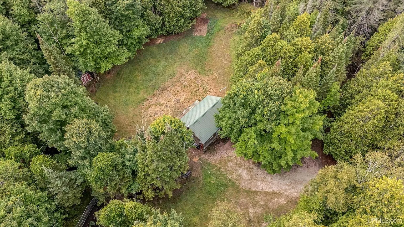 Aerial straight down on the cottage in its clearing among the trees