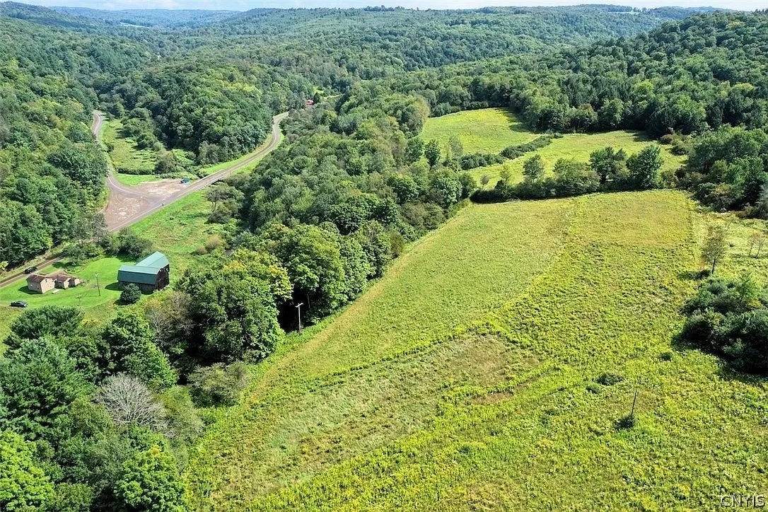The barn and the long fields climbing the hill from the air