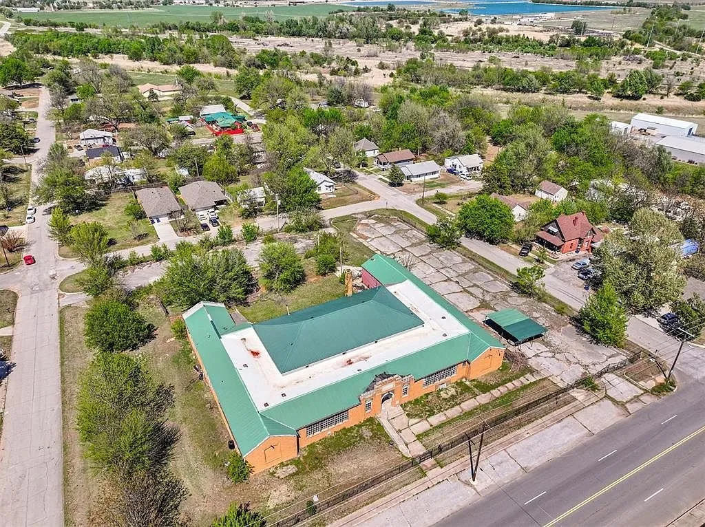 The school and its block from the air with the neighborhood around it and a lake beyond