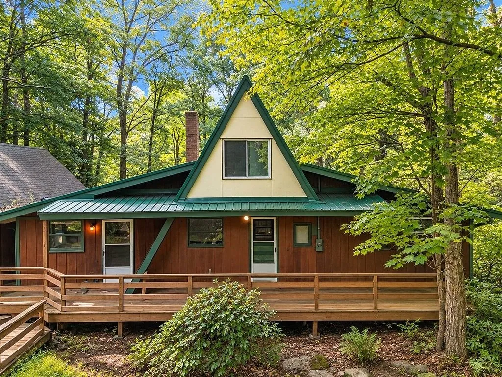 The A-frame framed by trees from the front walk