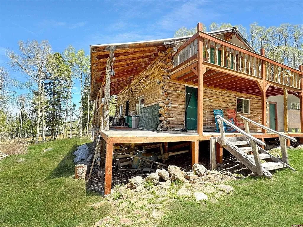 The cabin from the downhill side with the upper balcony and the stairs