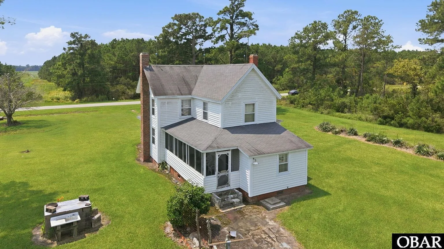 The house from the back with the porch and the mown yard