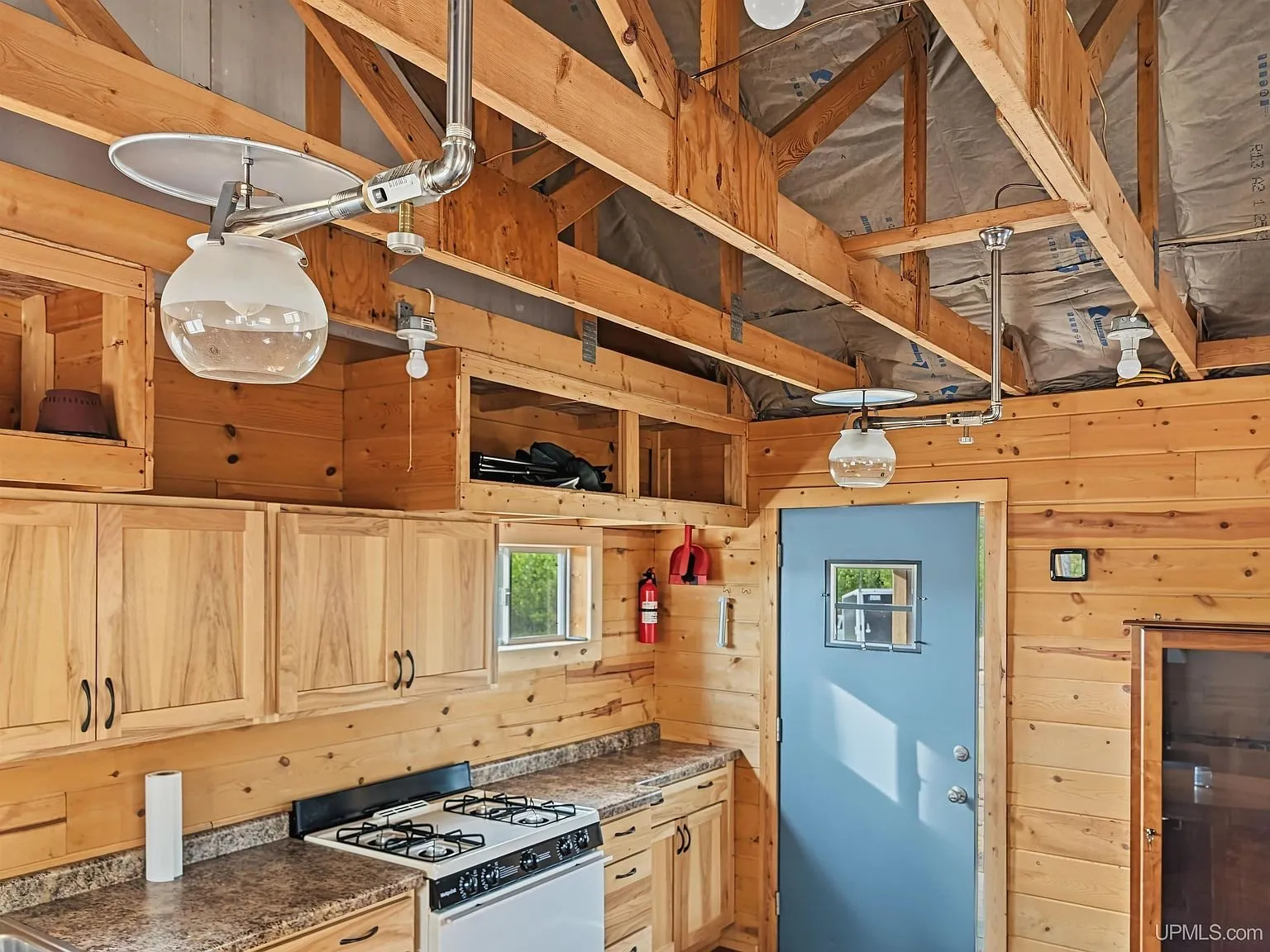 The vaulted interior with exposed beams and a ceiling fan